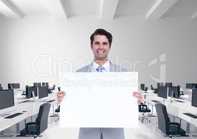 Happy business man holding blank card in office