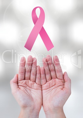 Open hands with pink ribbon for breast cancer awareness