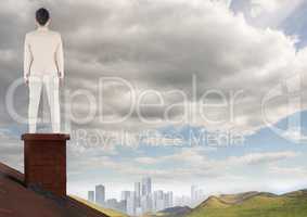 Businessman on roof chimney with city in distance