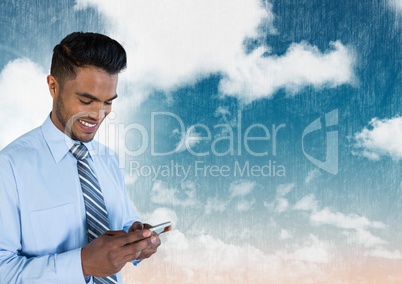 Businessman on phone under sky clouds