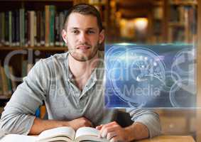 Male Student studying with book and science education interface graphics overlay