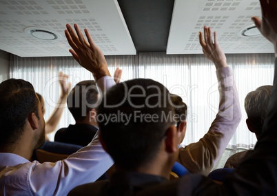 Business people with raised hands up at conference by windows