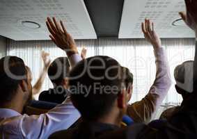 Business people with raised hands up at conference by windows