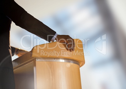 Businessman on podium speaking at conference with windows