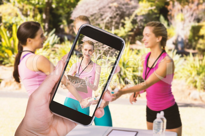 Composite image of hand holding mobile phone against white background