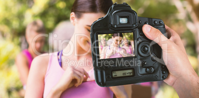 Composite image of cropped hand of photographer holding camera