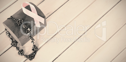 High angle view of jewelry with red box and pink Breast Cancer Awareness ribbon