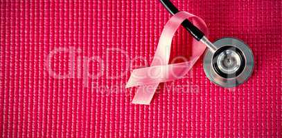 Directly above view of stethoscope by pink Breast Cancer Awareness ribbon