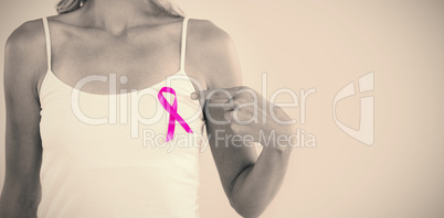 Mid section of young woman pointing at pink ribbon
