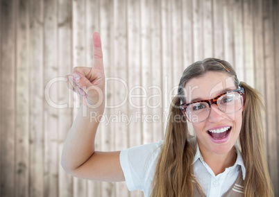 Nerd woman pointing up against blurry wood panel