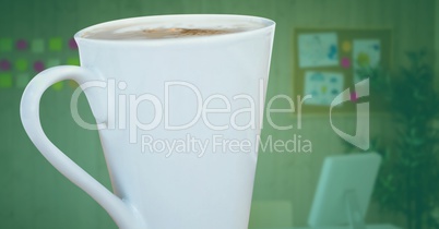 White coffee cup against blurry office with green overlay