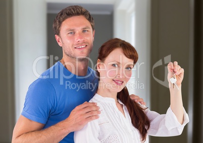 Couple Holding key in home corridor