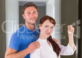 Couple Holding key in home corridor