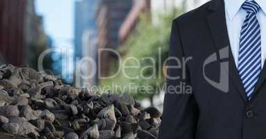 Ruibble stones in pile with businessman in city