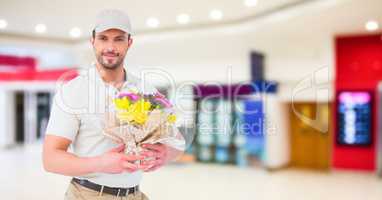 Delivery man with flowers against blurry shopping centre