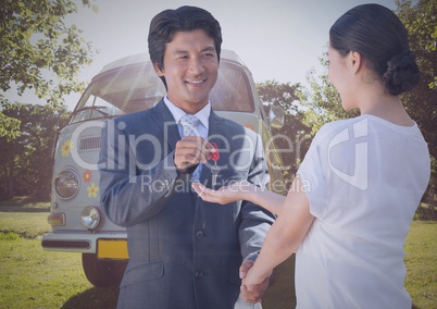 Man and woman with keys in front of camper van