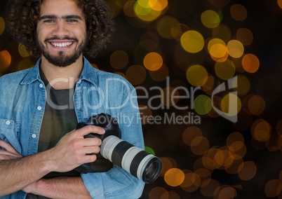 happy photographer with camera on hands. Orange and green bokeh background and overlap.