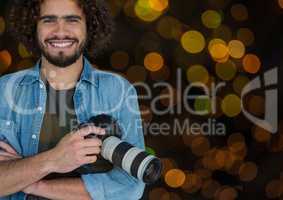 happy photographer with camera on hands. Orange and green bokeh background and overlap.