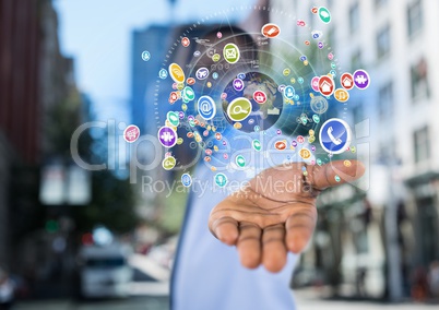 business man (blurred) with hand spread of with application icons and world. Blurred street backgrou