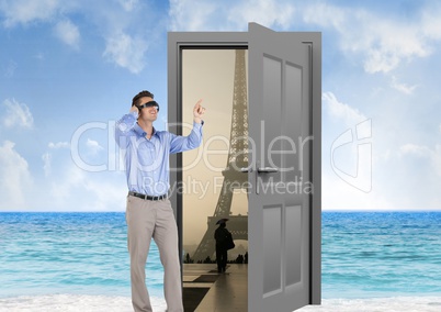 businessman with VR glasses in the beach with door to go to Paris