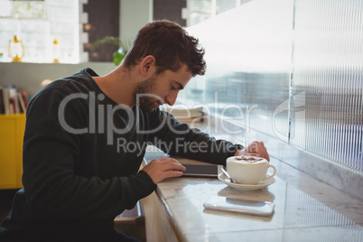 Man using tablet in cafe