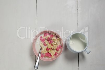 Bowl of honeycomb cereal and milk on wooden table