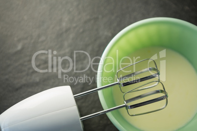 Overhead view of electric mixer by bowl with batter