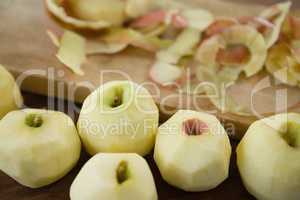 Close up of fresh apples by peels on cutting board