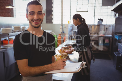 Portrait of waiter with clipboard in cafe