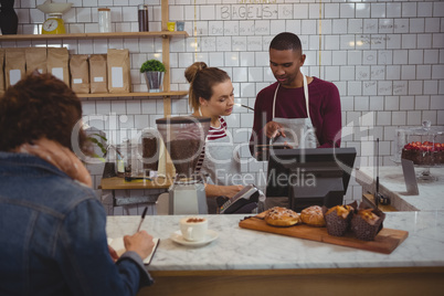 Owner with woman using tablet in cafe