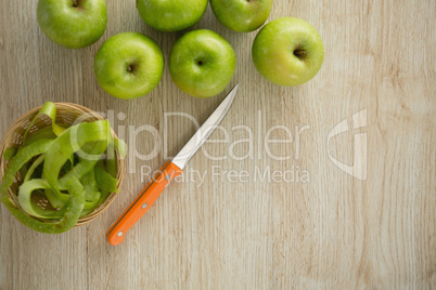 Overhead view of granny smith apples by peel in basket