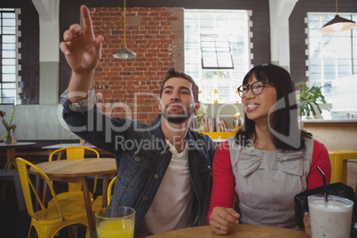 Man with woman pointing in cafe