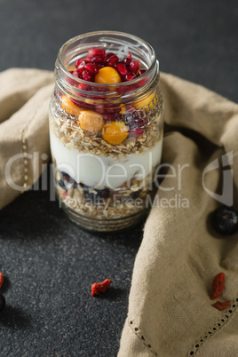 Yogurt with pomegranates and golden berries in glass jar