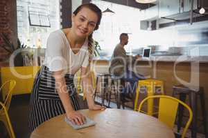 Portrait of waitress cleaning table