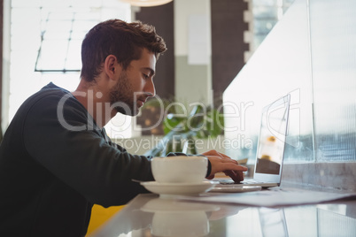 Businessman using laptop at cafe