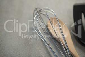 High angle view of wire whisk and wooden spoon