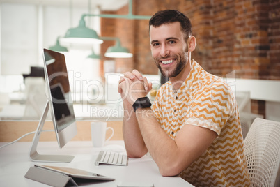 Portrait of smiling male executive sitting at desk