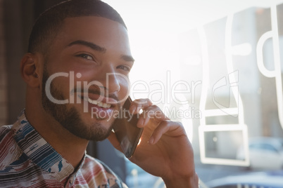 Portrait of man talking on mobile phone in cafe