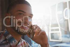 Portrait of man talking on mobile phone in cafe