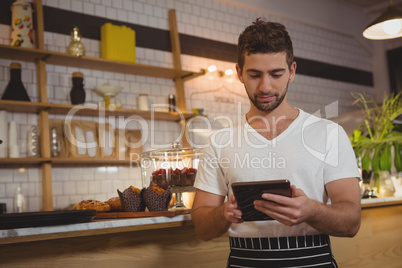 Waiter using tablet at cafe