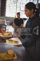Waitress holding plates with food in cafe