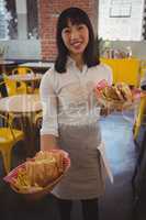 Portrait of waitress holding baskets with sandwiches