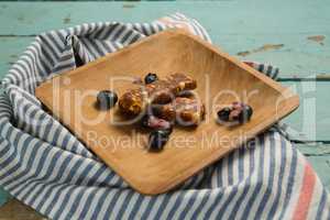 Granola bar and blueberry on wooden plate