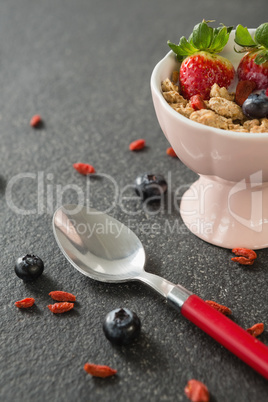 Bowl of breakfast cereals and fruits with spoon