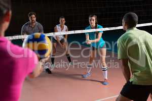 Players practicing volleyball at court