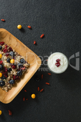 Plate of breakfast cereal and yogurt on black background