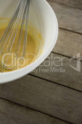 Cropped image of batter and wire whisk in bowl