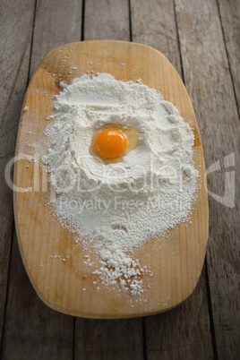 High angle view of egg yolk in flour on cutting board