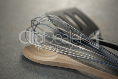 Close up of wooden spoon with wire whisk and spatula
