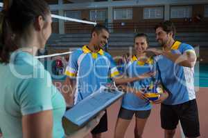 Female coach with volleyball players